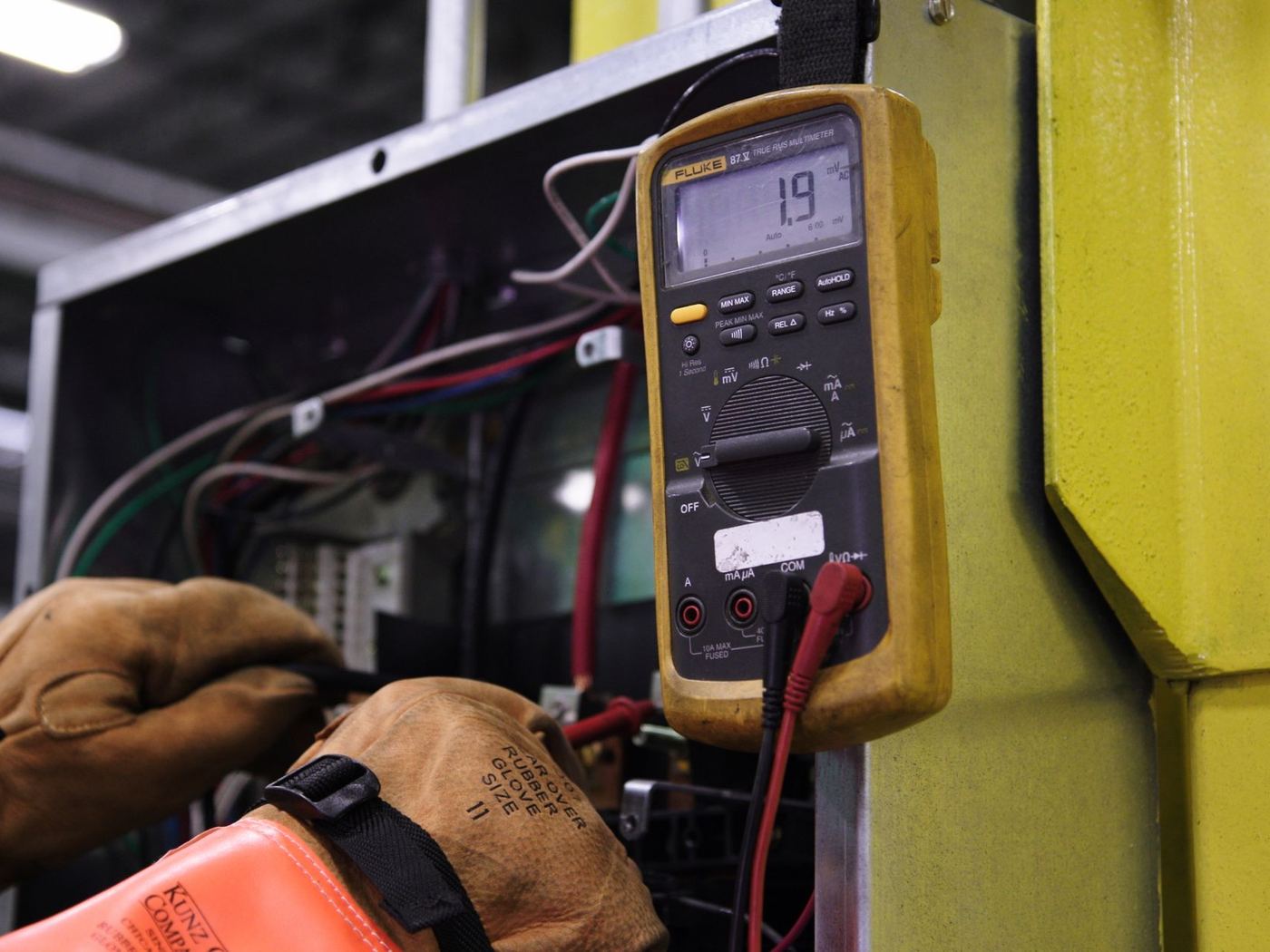 Electrician testing an electrical panel with a multimeter