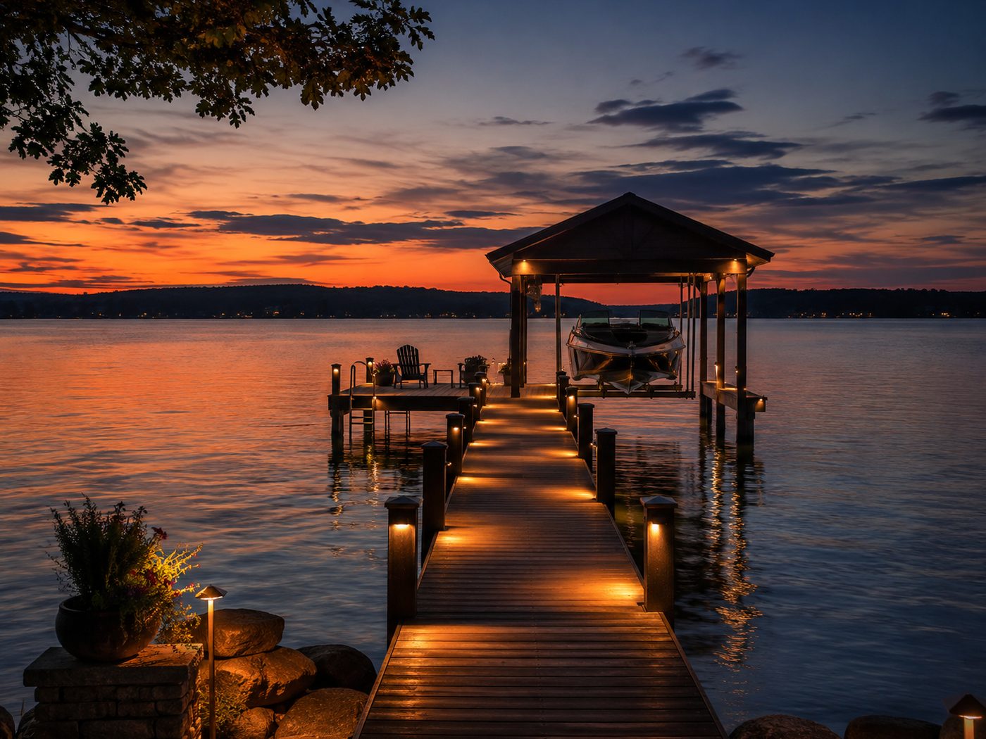 Private dock at sunset with post lights and a lit covered boathouse